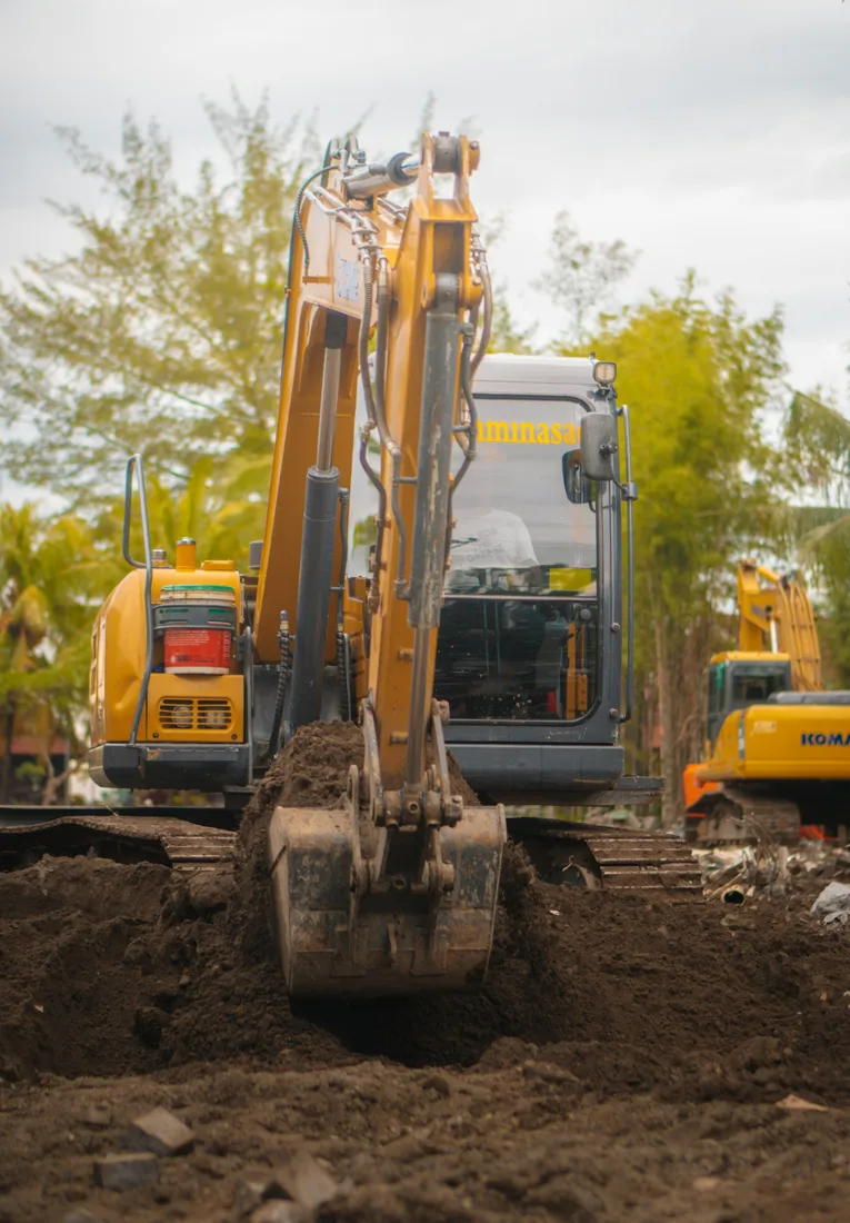 Excavator bucket cutting exposed soil